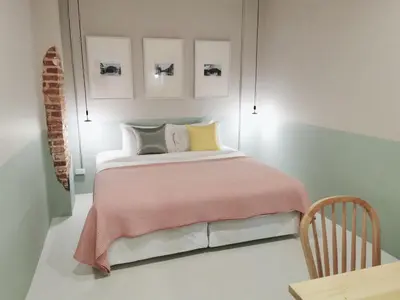 a bedroom with a bed with a pink blanket at Snoozy Guesthouse in Phuket Town