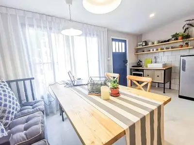 a kitchen and dining room with a wooden table at Snoozy Guesthouse in Phuket Town