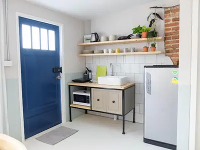a kitchen with a blue door and a refrigerator at Snoozy Guesthouse in Phuket Town