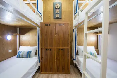 a room with two bunk beds and a clock on the wall at Hanuman VIP Hostel in Bang Tao Beach