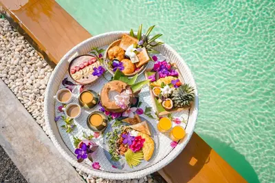 a tray of food on a table next to a pool at Roost Glamping - SHA Certified in Rawai Beach