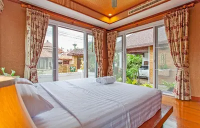 a bedroom with a large bed and large windows at Thai style villa with very beautiful private pool in Kamala Beach