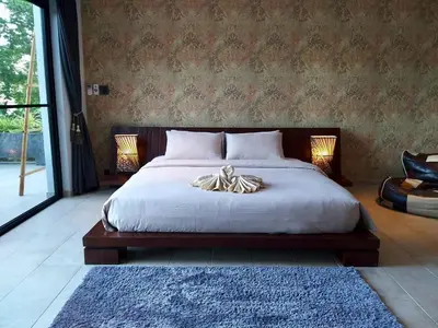 a bedroom with a large bed with a white blanket at Infinity Pool Apartment at Viewpoint Villas in Nai Harn Beach