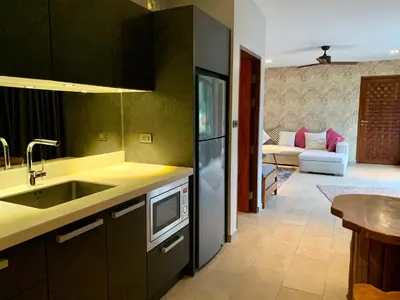 a kitchen with a sink and a couch in a room at Infinity Pool Apartment at Viewpoint Villas in Nai Harn Beach
