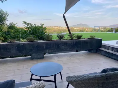 a patio with a table and chairs and a view at Infinity Pool Apartment at Viewpoint Villas in Nai Harn Beach