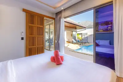 a bedroom with a bed and a view of a pool at New Boutique Pool Villa Sequoia Close to Rawai and Naiharn Beach in Rawai Beach