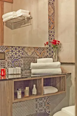 a bathroom with a shelf with towels and a mirror at Palmyrah Surin Apartments by Beringela in Surin Beach