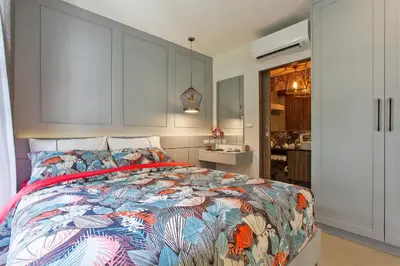 a bedroom with a bed with a colorful comforter at Palmyrah Surin Apartments by Beringela in Surin Beach