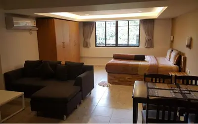 a living room with a couch and a bed at Oasis Apartments & Bar in Karon Beach