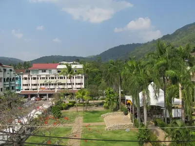a view of a resort with palm trees and a building at Oasis Apartments & Bar in Karon Beach