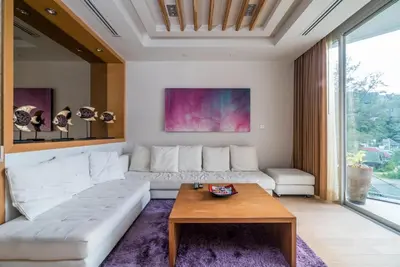 a living room with a white couch and a table at Bright beachfront retreat in Bang Tao in Bang Tao Beach