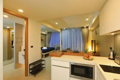 a kitchen and living room with a couch in the background at Oceanstone by Holy Cow, studio, next building view in Bang Tao Beach