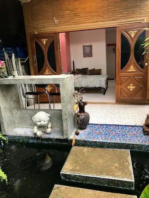 a living room with a fish pond and a room with a couch at Golf House in Ban Bang Phai