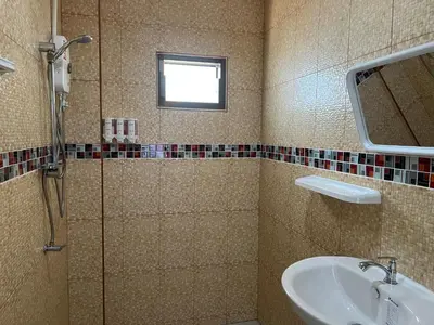 a bathroom with a sink and a shower at Golf House in Ban Bang Phai