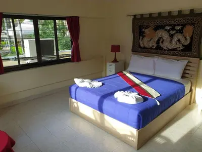 a bedroom with a bed with two towels on it at Oasis Guesthouse & Bar in Karon Beach