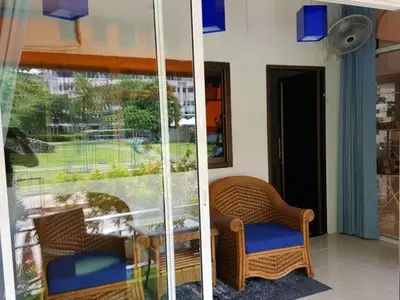 a room with a table and chairs and a window at Oasis Guesthouse & Bar in Karon Beach