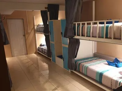 a room with two bunk beds and a hallway at Oasis Hostel & Bar in Karon Beach