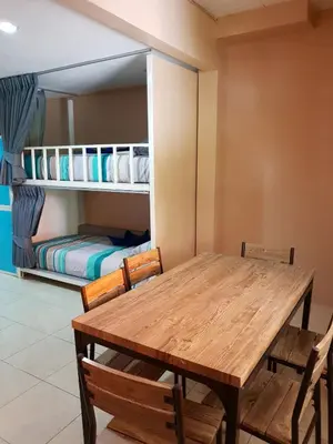 a dining room with a table and chairs and a bunk bed at Oasis Hostel & Bar in Karon Beach