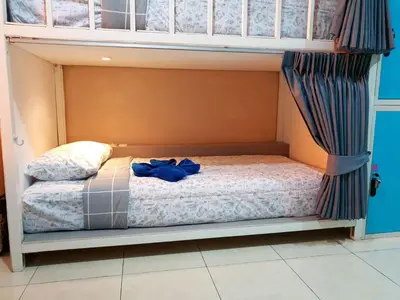 a bunk bed with a blue shirt on it at Oasis Hostel & Bar in Karon Beach