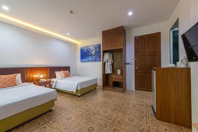a hotel room with two beds and a flat screen tv at Blue Beach Apartment in Rawai Beach