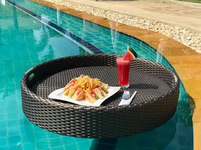 a table with a plate of food and a drink at Blue Beach Apartment in Rawai Beach