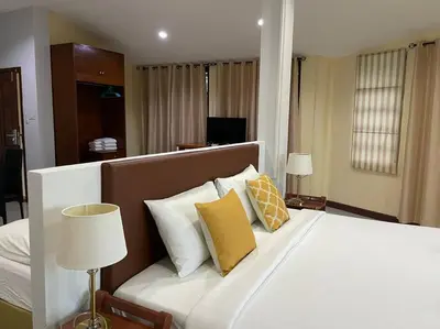 a bedroom with a white bed with yellow pillows at Blue Beach Apartment in Rawai Beach