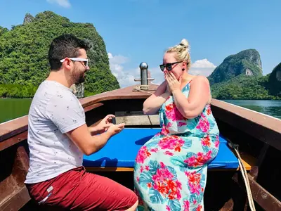 a man and a woman sitting on a boat at Jamesbond Bungalow Koh Panyee in Ko Panyi