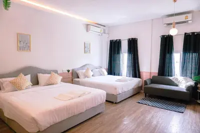 a bedroom with two beds and a couch and a chair at Isara Boutique Hotel and Cafe in Phuket Town