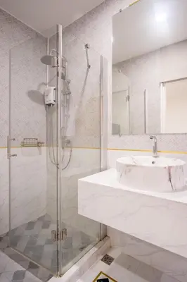 a white bathroom with a sink and a shower at Isara Boutique Hotel and Cafe in Phuket Town
