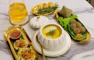 a table with plates of food and a glass of juice at Isara Boutique Hotel and Cafe in Phuket Town