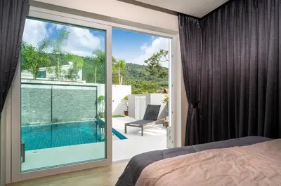 a bedroom with a large glass door leading to a swimming pool at Villa Kamala close to the beach in Kamala Beach