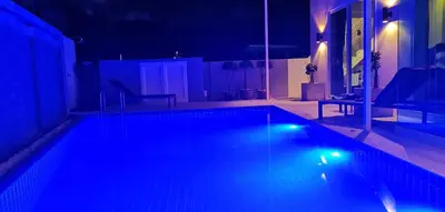 a swimming pool with blue lights in a room at Villa Kamala close to the beach in Kamala Beach