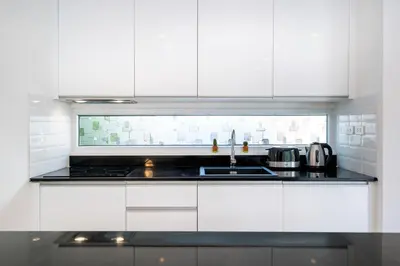 a white kitchen with a sink and a stove at Villa Kamala close to the beach in Kamala Beach