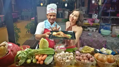 a man and a woman holding a plate of food at PP Red Tuna Hut in Phi Phi Don
