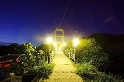 a bridge lit up at night with lights on it at PP Red Tuna Hut in Phi Phi Don