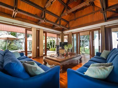 a living room with blue couches and a table at Villa Chada in Kamala Beach