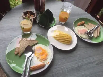 a table with plates of breakfast foods and drinks at Mookanda bungalow in Ko Yao Noi