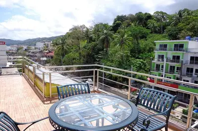 a patio with a table and chairs on a balcony at Sukcheewa Residence Phuket in Patong Beach
