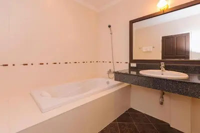 a bathroom with a tub and a sink and a mirror at Sukcheewa Residence Phuket in Patong Beach