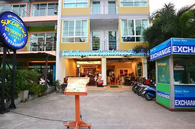 a sign in front of a building with motorcycles at Sukcheewa Residence Phuket in Patong Beach