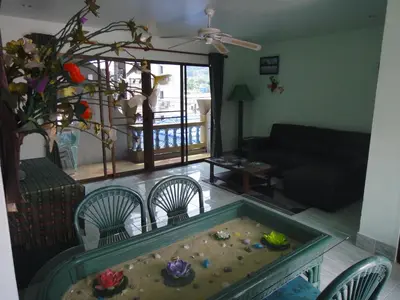 a living room with a table and chairs and a fish tank at Patong Sunbeach Mansion in Patong Beach