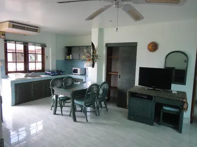 a kitchen with a table and chairs and a television at Patong Sunbeach Mansion in Patong Beach