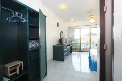 a room with a bedroom with a dresser and a desk at Patong Sunbeach Mansion in Patong Beach