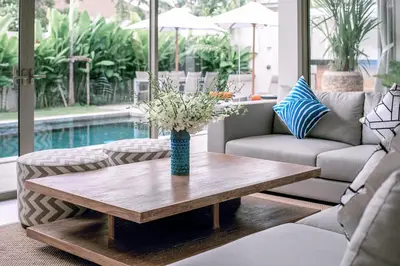 a vase of flowers on a coffee table in a living room at Modern 3BR Villa with Private Pool and BBQ in Bang Tao Beach