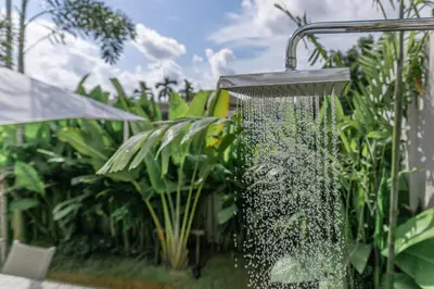 a shower in a garden with green plants at Modern 3BR Villa with Private Pool and BBQ in Bang Tao Beach