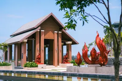 a building with red fish statues in front of it at Mida Grande Resort Phuket Official Account in Surin Beach