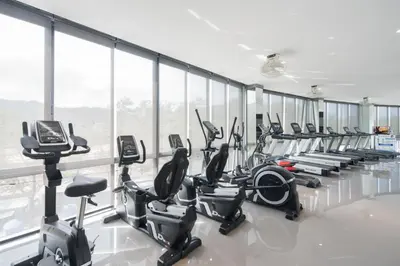 a gym with rows of treadmills and exercise bikes at Citygate Kamala Resort and Residence - Official Account in Kamala Beach