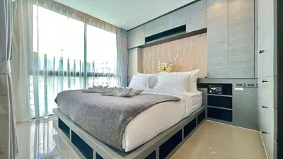 a large bed in a room with a large window at Citygate Kamala Resort and Residence - Official Account in Kamala Beach