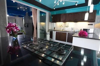 a kitchen with a stove and a counter with purple flowers at Baan Heaven / Patong Beach Pool Villa Sleeps up to 15 in Patong Beach