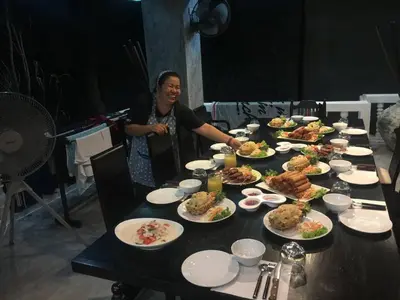 a woman standing in front of a table full of food at Baan Heaven / Patong Beach Pool Villa Sleeps up to 15 in Patong Beach